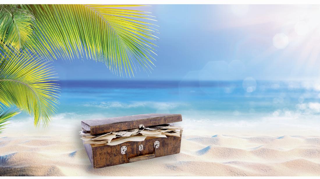 Koffer mit Briefen am Strand einer einsamen Insel