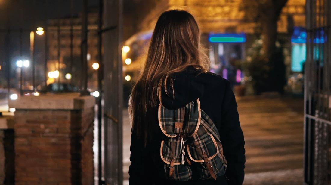 Mädchen mit Rucksack im nächtlichen Paris